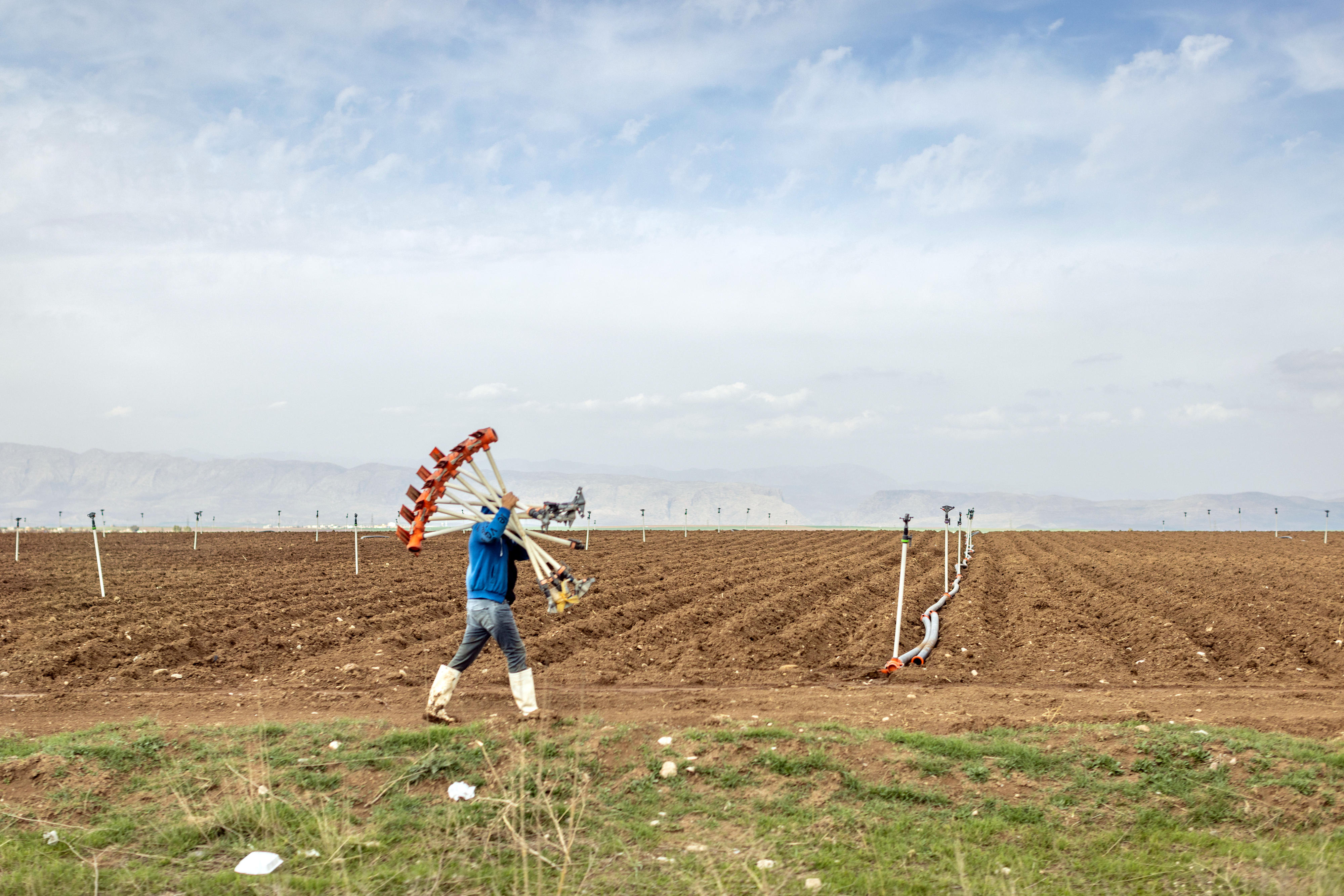 Ein Bauer trägt Bewässerungsrohre zu einem Feld nahe Zakho, Irak.