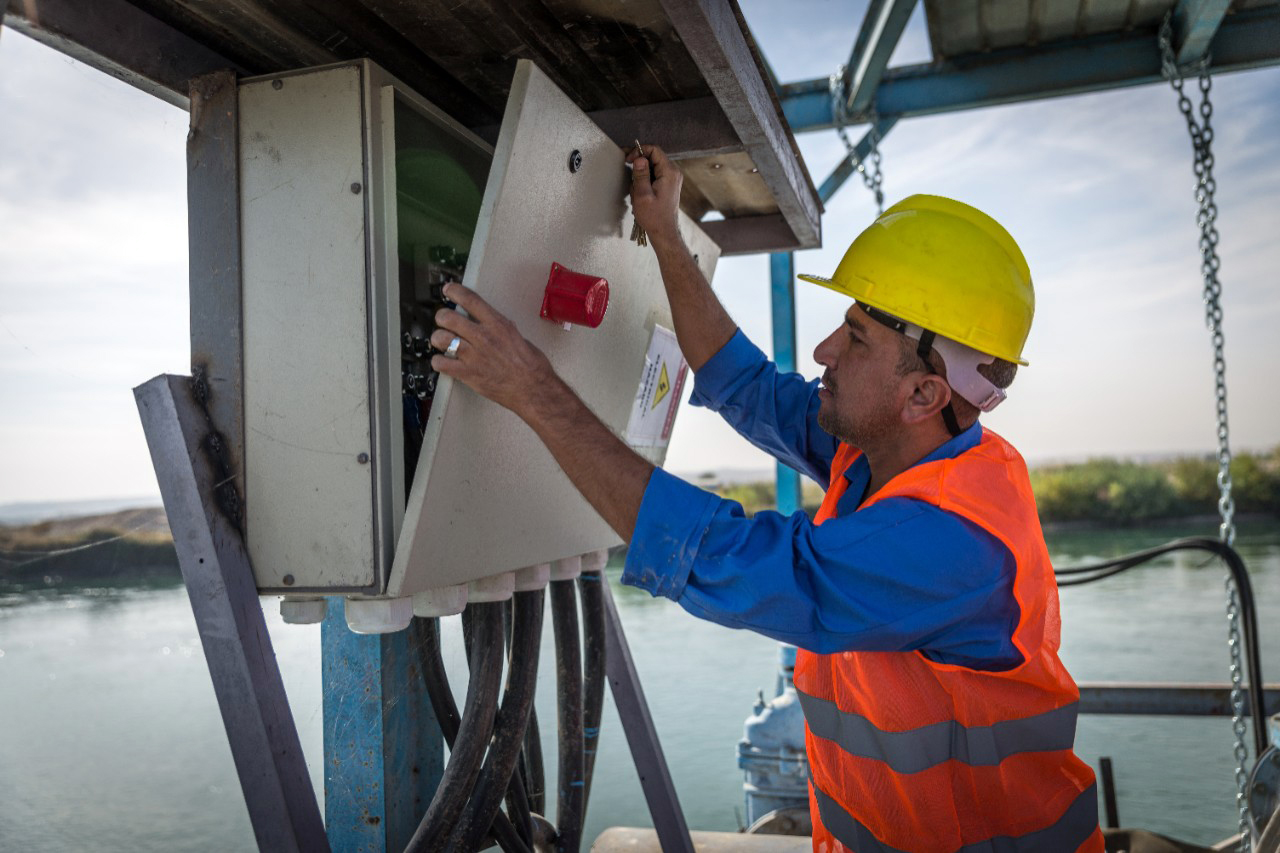 An employee of the Al-Saheroon sewage treatment plant near Mosul checks lines.