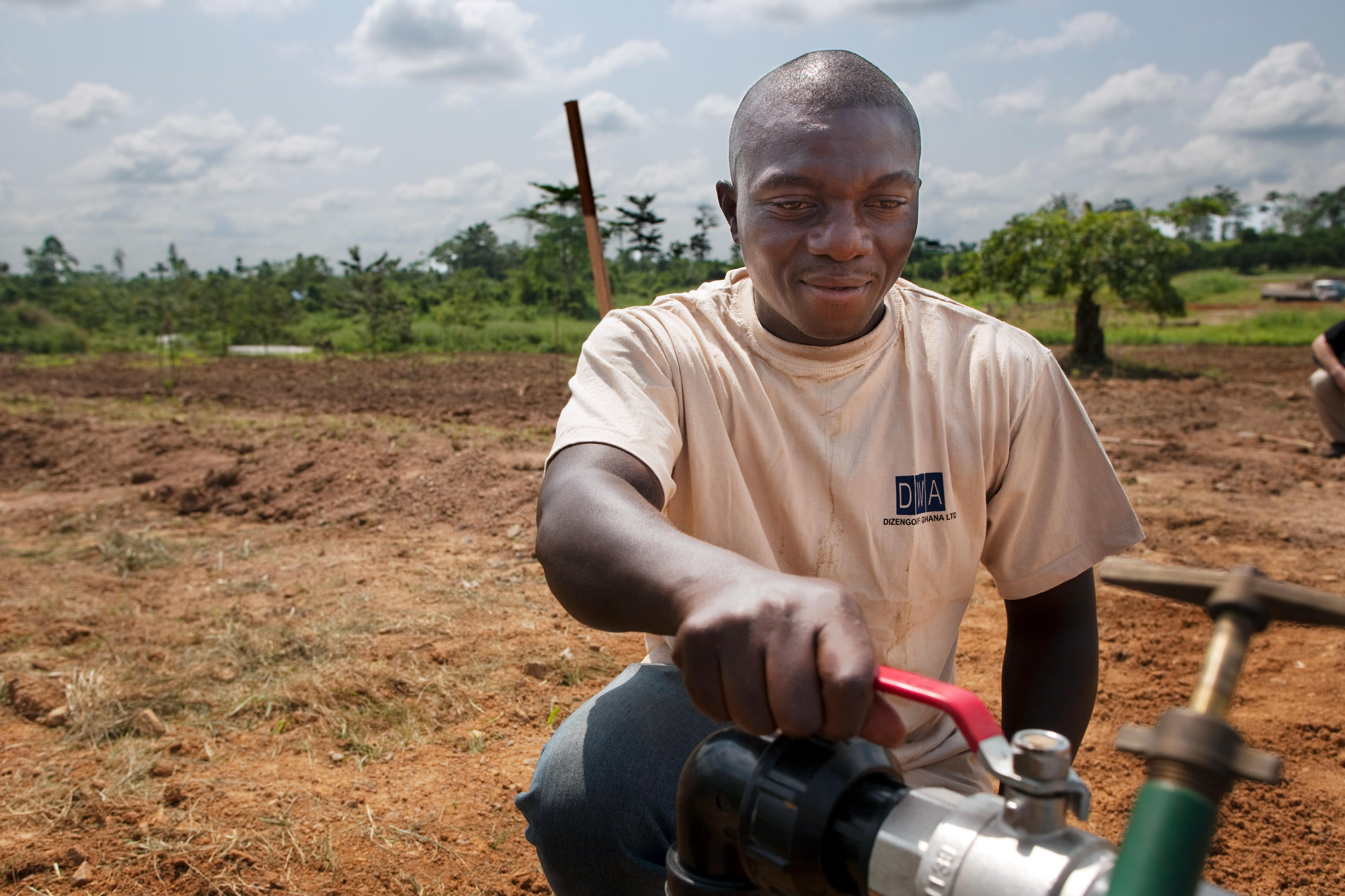 A man operates a water pump in a field in Asamankese, Ghana.