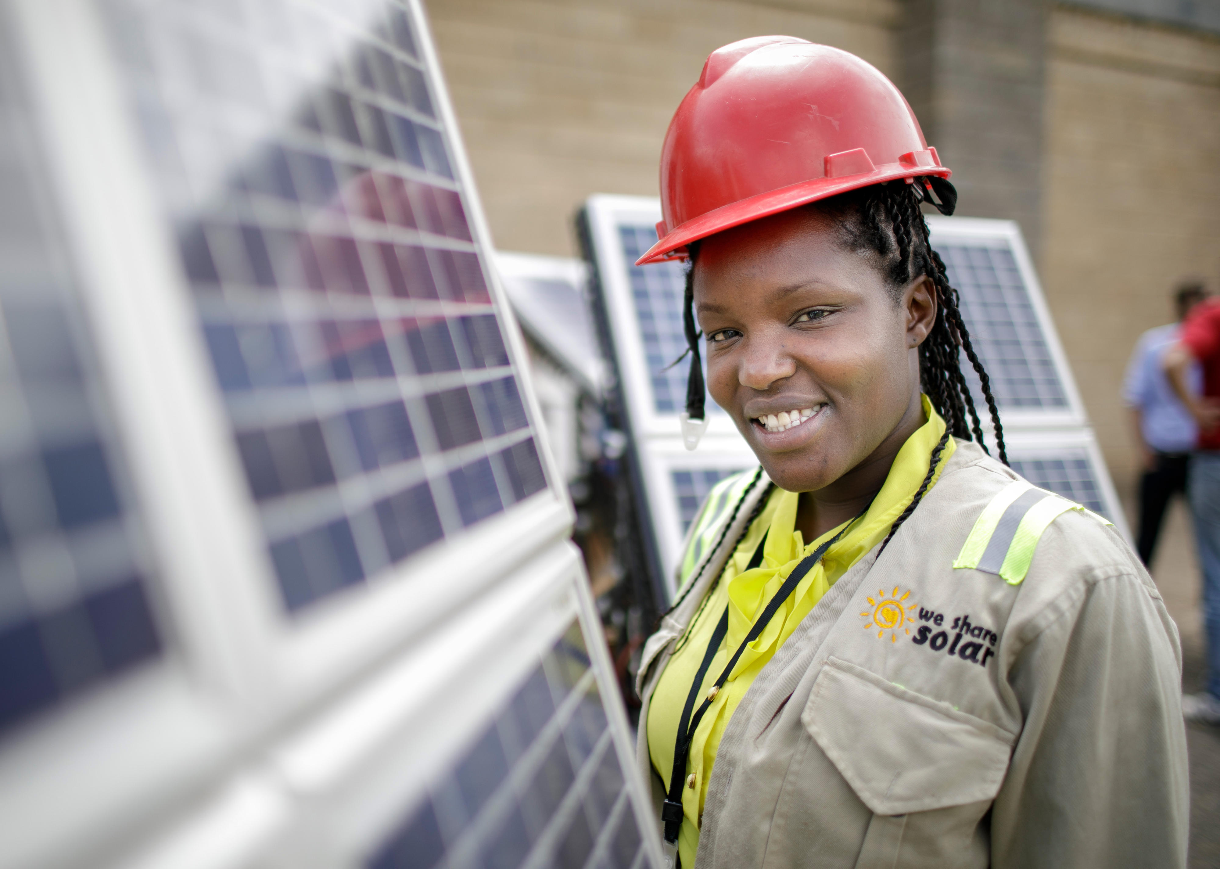 Student next to solar panels in a training facility for solar technicians and energy auditors at Strathmore University, Nairobi